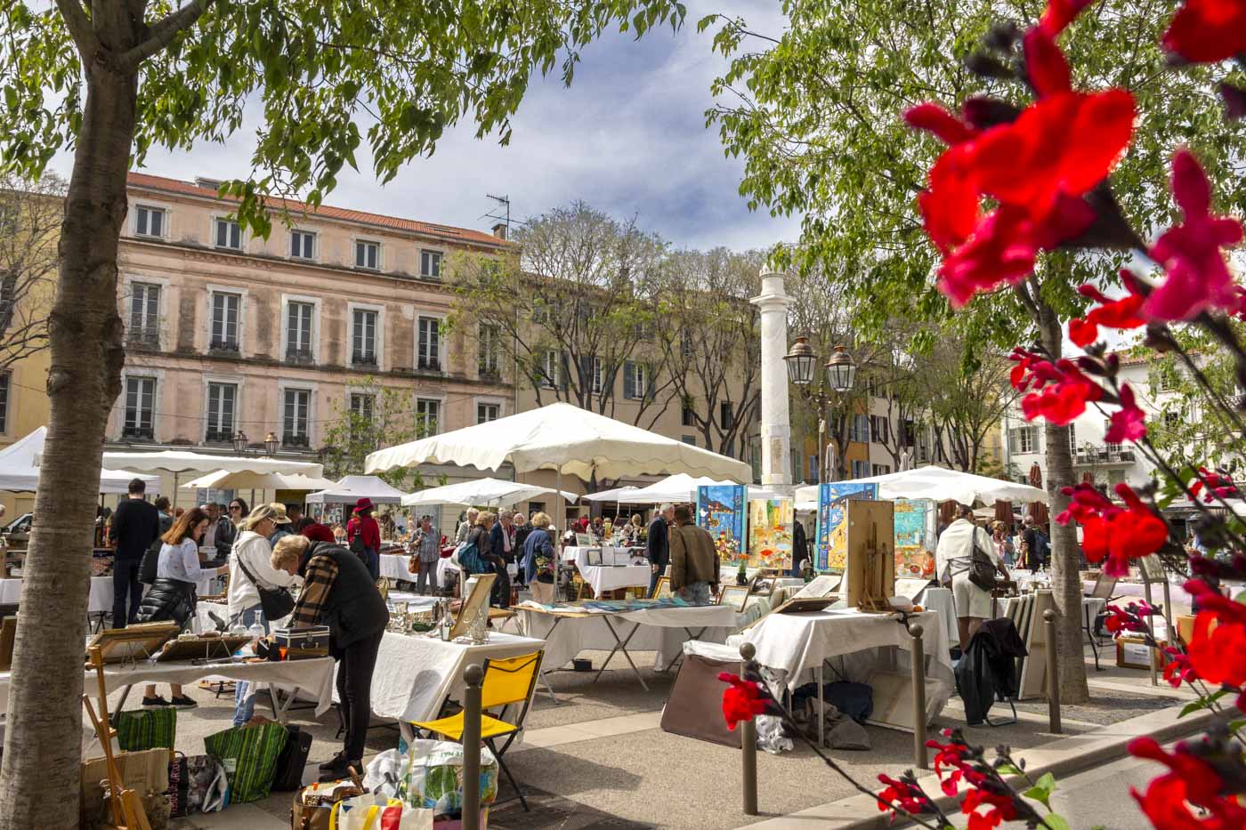 Mercatino dell'antiquariato in una piazza di Antibes, con bancarelle di oggetti vintage e curiosità d'epoca